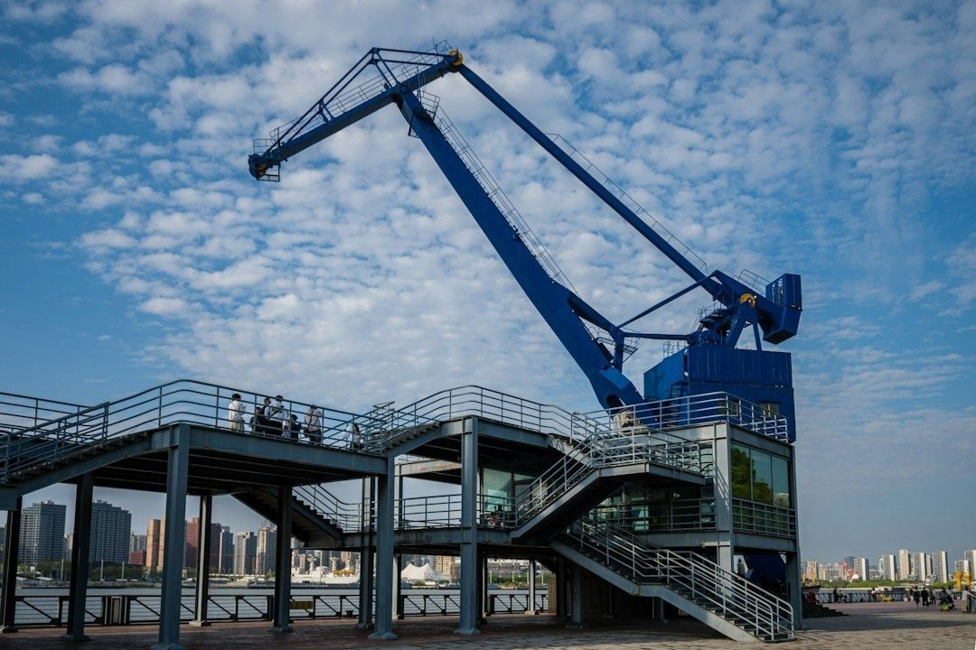 Stalen buitenconstructie met kraan aan het water onder een bewolkte hemel
